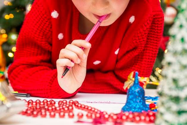 Cute boy in Santa hat writes a letter to Santa near the Christmas tree Little child writes letter to Santa. Cute boy in Santa hat writes a letter to Santa near the Christmas tree. Copyright: x RECORD DATE NOT STATED