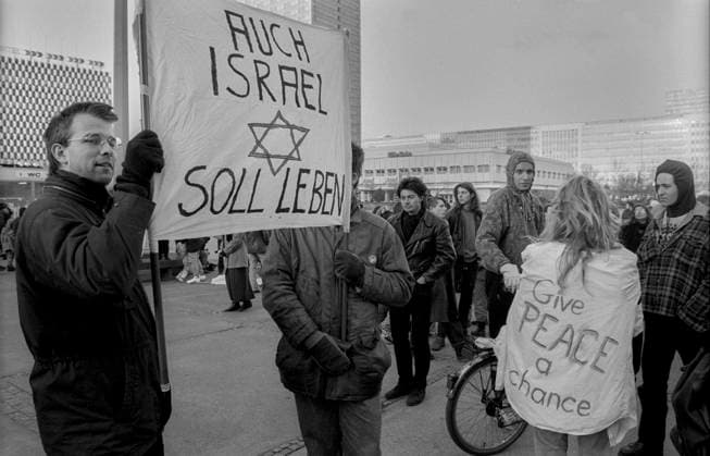 Archivbilder der Woche KW20 Demo gegen Golfkrieg Deutschland, Berlin, 04.01.1991, Demo gegen Golfkrieg, auf dem Alexanderplatz, in der vereinzelte Transparente für Israel auftauchen: Auch Israel soll leben Give peace a chance, Â *** Demo against Gulf War Germany, Berlin, 04 01 1991, Demo against Gulf War, on Alexanderplatz, in which scattered banners for Israel appear Also Israel shall live Give peace a chance, Â