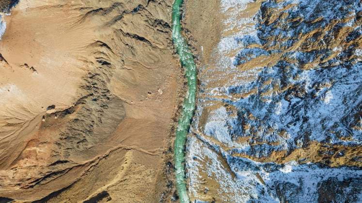 Creative Highlights World Long river with green water in Charyn Canyon A long river with green water in the Charyn Canyon. There is white snow in places. Bushes and trees grow. The river runs through a canyon among rocks and cliffs. Mountains are visible. Drone view Copyright: x RECORD DATE NOT STATED