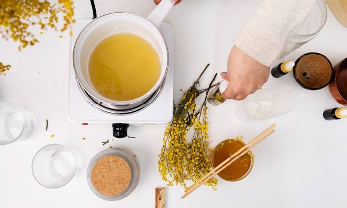 Woman making decorative aroma candle at table, top view Creative hobby at home. Woman making decorative aroma candle at table, stirring melting soy wax in the pot, flat lay Copyright: x RECORD DATE NOT STATED