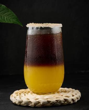 Iced coffee with orange juice in a transparent glass, refreshing bumble coffee on the table, black background Copyright: xDANKOxN RECORD DATE NOT STATED