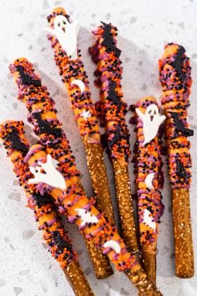 Halloween chocolate-covered pretzel rods Flat lay. Halloween chocolate-covered pretzel rods with sprinkles on a kitchen counter. Copyright: xArinaxHabich RECORD DATE NOT STATED