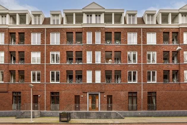 the building in which the hotel is located an apartment building with many windows and bales on the top floor, in front of it is a red brick wall Copyright: xChristofxSchad RECORD DATE NOT STATED