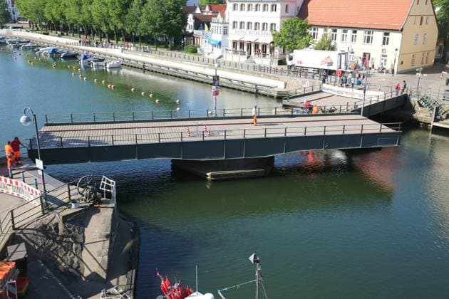 News Bilder des Tages Blick am Donnerstag (16.05.2024) im Ostseebad Warnemünde, ein Ortsteil der Hanse- und Universitätsstadt Rostock, auf die teilweise geöffnete Drehbrücke über den Alten Strom. An der Brücke wurden im Verlauf des Tages Reparaturarbeiten durchgeführt. Dazu wurde an einigen Stellen der Korrosionsschutz erneuert. Dahingehend wurde die Brücke am Vormittag in zwei Phasen gedreht und für den öffentlichen Verkehr gesperrt. So mussten die Passanten zur besten Frühstückszeit entweder die Brücke umlaufen oder an den beiden Zugängen solange warten bis das Bauwerk wieder seine ursprüngliche Position eingenommen hat. Daraufhin sammelten sich an den beiden Absperrungen immer wieder zahlreiche Schaulustige. Zumal das Öffnen Brücke nur sehr selten passiert.