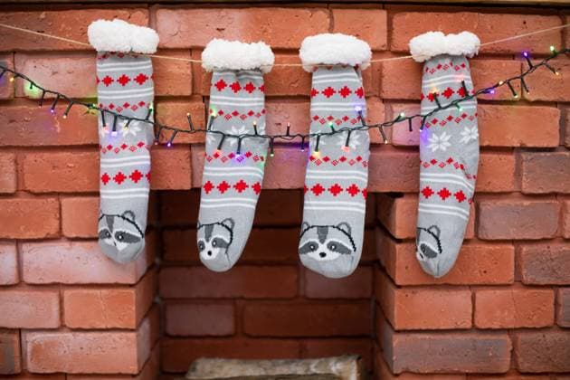 Decorated bricks fireplace with gray socks and Christmas lights. Christmas decoration on the fireplace with bricks of Christmas socks and Christmas tree lights. Copyright: xDANIELxDROBIK RECORD DATE NOT STATED