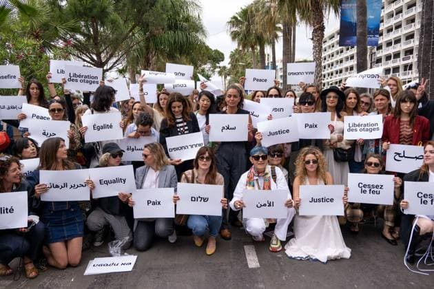 Cannes - Guerrieres De La Paix Flash Mob Action for Gaza and Israel Women from ?Women warriors of peace? carrying messages in French, Arabic, Hebrew and English stating ?Peace?, ?Cease Fire?, Release the Hostages?, demonstrate on the ?Croisette? in Cannes, to draw attention to the situation in Gaza and Israel, around the 77th Cannes Film Festival, in Cannes, France, on May 20, 2024. Photo by Ammar Abd Rabbo ABACAPRESS.COM Cannes France  Copyright: xABACAx