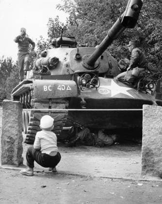 Bau der Berliner Mauer Ein Berliner Junge hockt vor einem US-Panzer, an bzw. unter dem US-Soldaten zu Gange sind, Berlin 1961. Originale Bildbeschreibung: Momentane Situation an den Grenzen Westberlins - Wildernbruchstr. sic. , Berlin Copyright: Kindermann Nur redaktionelle Nutzung Editorial use only KIN_740302092 EDITORIAL USE ONLY