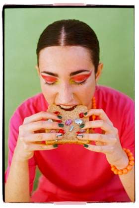 Creative Highlights Symbolbilder Young woman eating gemstones sandwich against green background model released, Symbolfoto, EGHF00943