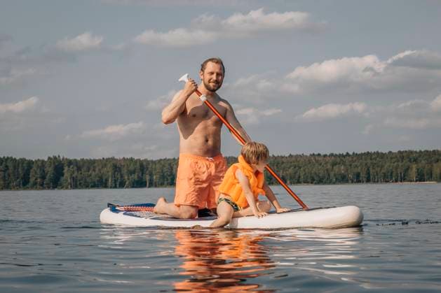 Shirtless man with son on SUP board in sea at sunny day model released, Symbolfoto, EVKF00132