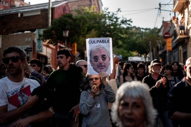 May 23, 2024, Barcelona, Spain: In the Park Guell neighborhood of Barcelona a woman holds a placard with the face of the city s mayor Jaume Collboni and guilty written. Barcelona residents gathered around Park GoÂ¼ell in Barcelona against the Louis Vuitton fashion show and protesting various social issues such as mass tourism, gentrification, animal rights or the commercialization and privatization of public spaces by the city council. Barcelona Spain - ZUMAb137 20240523_fap_b137_001 Copyright: xJordixBoixareux