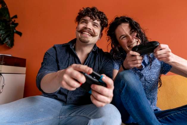 IMAGO Creative, Lifestyle, Gaming Cheerful couple playing video game at home model released, Symbolfoto property released, JOSEF24254