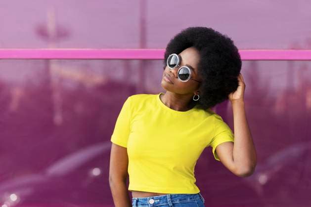 Creative Highlights Symbolbilder Young Afro woman wearing sunglasses in front of magenta window model released, Symbolfoto, LMCF01166
