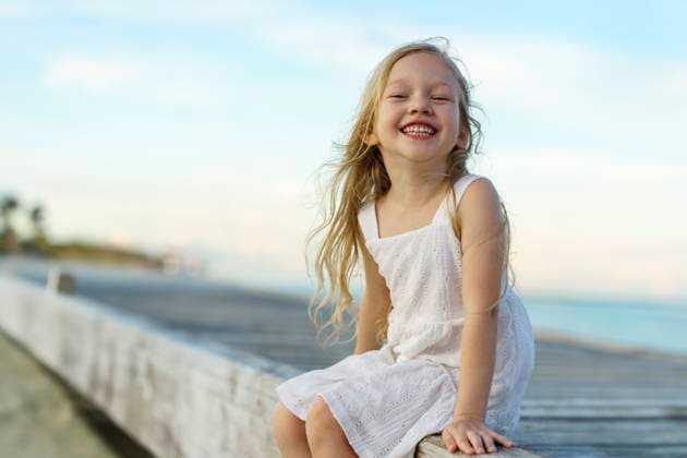 Creative Highlights Symbolbilder Happy girl sitting on jetty at beach model released, Symbolfoto, NSTF00149