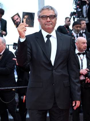Cannes, France: Cannes, 77th Cannes Film Festival 2024, Eleventh Evening - Director Rasoulof parades with photos of the actors stranded in Iran on the red carpet of The Seed of the Sacred Fig Cannes France  - ZUMAp169 20240524_zea_p169_763 Copyright: xSimonexComix