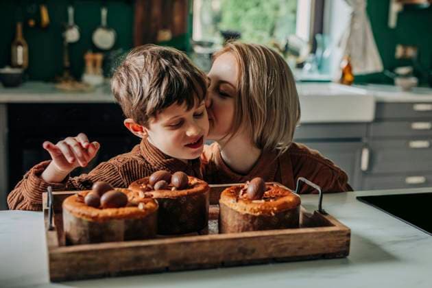 Woman kissing son near Easter cakes with chocolate eggs in kitchen model released, Symbolfoto, VSNF01914