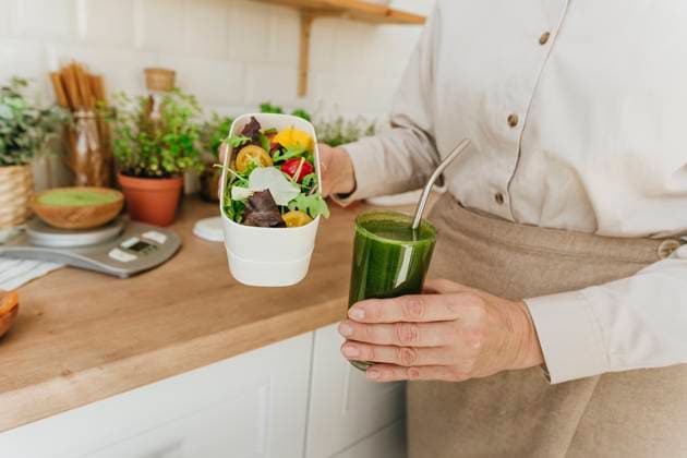Woman holding salad and detox juice in kitchen at home model released, Symbolfoto property released, YTF00886
