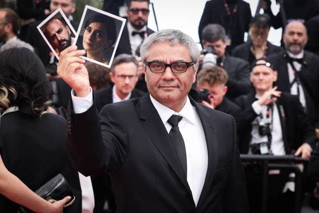 Cannes The Seed Of The Sacred Fig Exit Screening DB Iranian director Mohammad Rasoulof holds portrait of Iranian actor Missagh Zareh (L) and Iranian actress Soheila Golestani as he departs the The Seed Of The Sacred Fig Red Carpet at the 77th annual Cannes Film Festival at Palais des Festivals on May 24, 2024 in Cannes, France. Photo by David Boyer ABACAPRESS.COM Cannes France  Copyright: xBoyerxDavid ABACAx