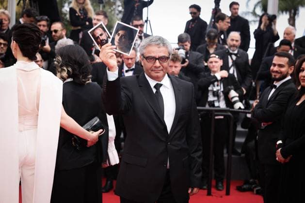 Cannes The Seed Of The Sacred Fig Exit Screening DB Iranian director Mohammad Rasoulof holds portrait of Iranian actor Missagh Zareh (L) and Iranian actress Soheila Golestani as he departs the The Seed Of The Sacred Fig Red Carpet at the 77th annual Cannes Film Festival at Palais des Festivals on May 24, 2024 in Cannes, France. Photo by David Boyer ABACAPRESS.COM Cannes France  Copyright: xBoyerxDavid ABACAx