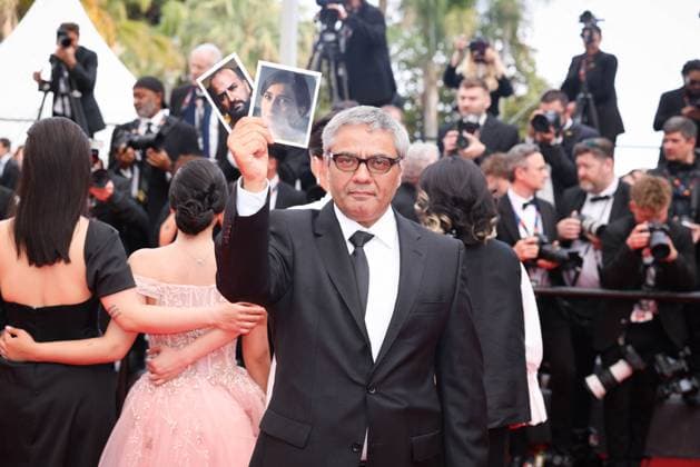 Cannes The Seed Of The Sacred Fig Exit Screening DB Iranian director Mohammad Rasoulof holds portrait of Iranian actor Missagh Zareh (L) and Iranian actress Soheila Golestani as he departs the The Seed Of The Sacred Fig Red Carpet at the 77th annual Cannes Film Festival at Palais des Festivals on May 24, 2024 in Cannes, France. Photo by David Boyer ABACAPRESS.COM Cannes France  Copyright: xBoyerxDavid ABACAx