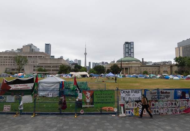 (240527) -- TORONTO, May 27, 2024 -- A person walks past a pro-Palestinian encampment at St. George Campus of the University of Toronto in Toronto, Canada, on May 27, 2024. Pro-Palestinian demonstrators who have been camped out at the University of Toronto, Canada, for 25 days held a solidarity rally on Monday. (Photo by Xinhua) CANADA-TORONTO-PRO-PALESTINIAN ENCAMPMENT ZouxZheng 