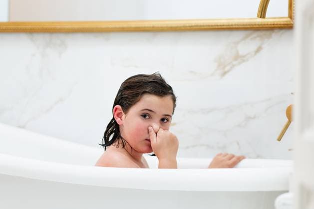 Creative Highlights Symbolbilder A playful girl with wet hair looks directly at the camera while sitting in a bathtub, fingers amusingly placed on her nose in a bright bathroom. Model Released HodeiUnzueta_ID21479_631734_029 Copyright: xHodeixUnzuetax