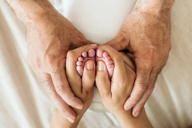 Creative Highlights Symbolbilder A tender image showcasing a newborn baby s feet gently held by the loving hands of parents, symbolizing care and family bond Model Released HodeiUnzueta_ID21677_635786_051 Copyright: xHodeixUnzuetax