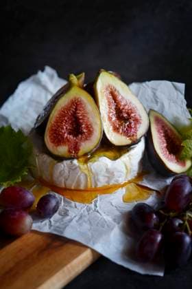 Brie cheese served with figs, honey and grapes, close up. Brie cheese served with figs, honey and grapes, close up. Copyright: xMilleflorexImagesx MIL230424-15
