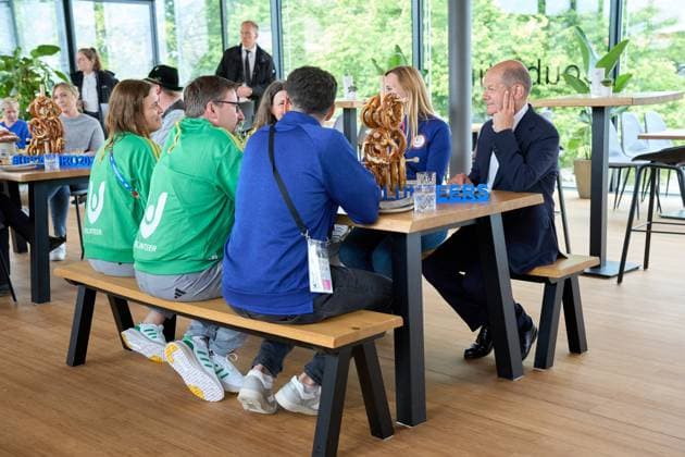 Munich, Bavaria, Germany - June 3, 2024: Federal Chancellor Olaf Scholz visits the Olympic Park in Munich, Bavaria on the occasion of UEFA EURO 2024. The Chancellor talks to helpers around the European Football Championship at a table with Bavarian pretzels