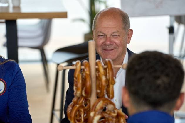 Munich, Bavaria, Germany - June 3, 2024: Federal Chancellor Olaf Scholz visits the Olympic Park in Munich, Bavaria on the occasion of UEFA EURO 2024. The Chancellor talks to helpers around the European Football Championship at a table with Bavarian pretzels