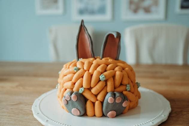 Bunny birthday cake decorated with carrots on a wooden table Thun, Canton of Bern, Switzerland R_FFVO240607D7-1450248-01