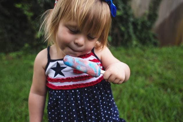 Creative Highlights Symbolbilder Young Girl in Patriotic dress eating a popsicle Fort Walton Beach, Florida, United States R_NYRF240607-1449891-01 ,model released, Symbolfoto