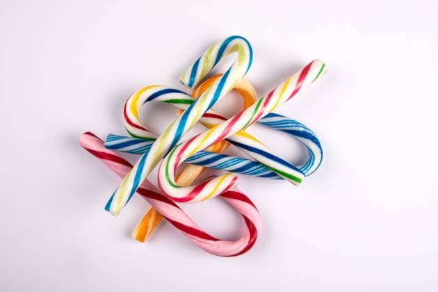 Different colored candy canes in a pile on a white background. Copyright: xEdgarsxSermulisx