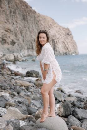 Creative Highlights Symbolbilder A woman is standing on a rock near the ocean wearing a white dress Playa de las Américas, Canary Islands, Spain R_TJHEAN2406113F-1456108-01 ,model released, Symbolfoto