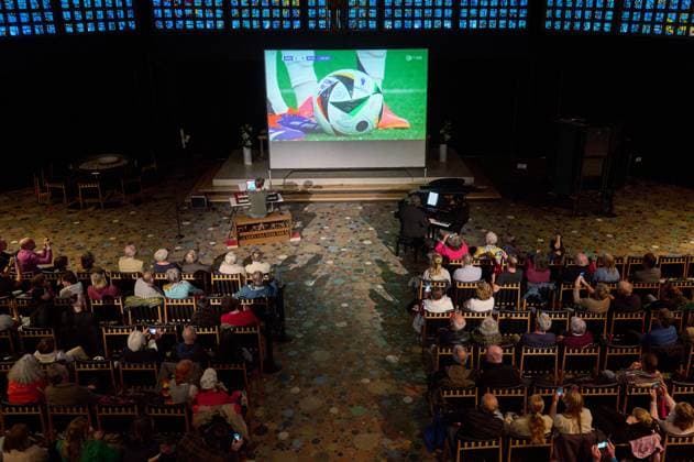 Die Kaiser-Wilhelm-Gedaechtniskirche in Berlin hat zum Eroeffnungsspiel der Fussball-EM Deutschland gegen Schottland am Freitag (14.06.2024) zum Public Viewing mit einem Orgel-Klavierduell eingeladen. Die Musiker Sebastian Heindl (Foto li.) und Jack Day (Foto re.) vertraten jeweils eine Mannschaft und begleiteten den aus Muenchen uebertragenen Spielverlauf live auf der Orgel und am Klavier. Waehrend der Fussball-Europameisterschaft veranstaltet die Kaiser-Wilhelm-Gedaechtniskirche bis 14. Juli ein eigenes Programm unter der Ueberschrift Willkommen im Blau . Unter dem Titel Anstoss! sollen auch die Mittagsgebete von Montag bis Freitag um 13 Uhr einen Bezug zum Fussball haben. Die Pfarrerinnen Kathrin Oxen und Sarah-Magdalena Kingreen werd Copyright: epd-bild ChristianxDitsch epd-Orgel-Klavierduell4