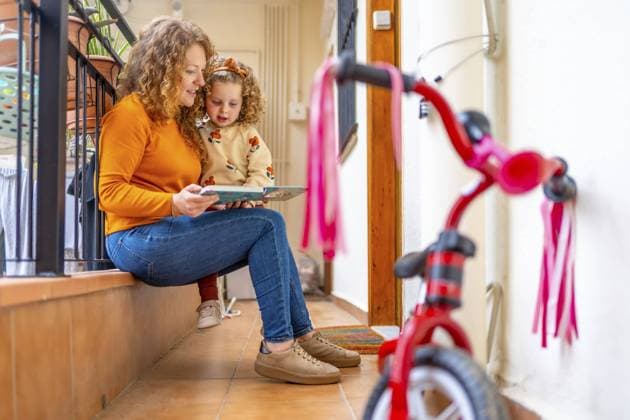 Mother Reading a Book to a Girl AT The Terrace of a Apartment Copyright: imageBROKER UnaixHuizi ibxuhu10785474.jpg ,model released, Symbolfoto ,property released