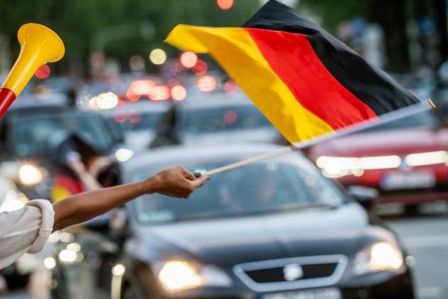 Soccer fans celebrate the German victory in the match against Hungary, woman waving German flag on Leopoldstraße, People of Color, Munich, June 19, 2024 Germany, Munich, Ju