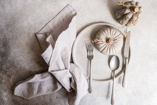 A tasteful autumnal flat lay featuring a neutral-toned table setting with a decorative pumpkin, gray plates, and linen napkin Ideal for seasonal design themes Model Released AnnaBogush_ID22171_648055_016 Copyright: xAnnaxBogushx