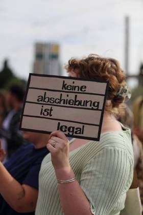 News Bilder des Tages Eine Demonstrantin mit Schild Keine Abschiebung ist legal während einer Demonstration gegen Abschiebungen anlässlich der Innenministerkonferenz (IMK) in Potsdam, 20. Juni 2024. Demo gegen Abschiebungen in Potsdam *** A demonstrator with a sign No deportation is legal during a demonstration against deportations on the occasion of the conference of interior ministers IMK in Potsdam, June 20, 2024 Demonstration against deportations in Potsdam