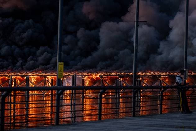 Kanada, Brand eines Docks im Hafen von Richmond June 20, 2024, Richmond, Bc, CANADA: A Richmond RCMP officer talks on the phone as a dock burns in Richmond B.C., on Thursday, June 20, 2024. Richmond CANADA  - ZUMAc35_ 20240620_zaf_c35_102 Copyright: xEthanxCairnsx