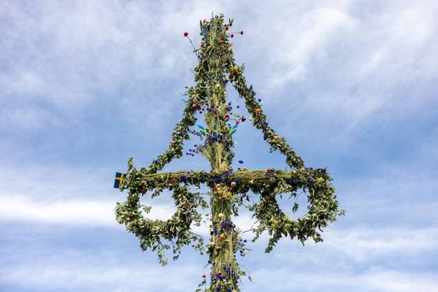 Mittsommer in Schweden Malmoe, Schweden - 21.6.2024: Menschen schmücken ihre Haare mit Blumenkränzen und feiern und tanzen um einen Midsommarstang Mittsommer im Folkets Park in Malmoe in Schweden.