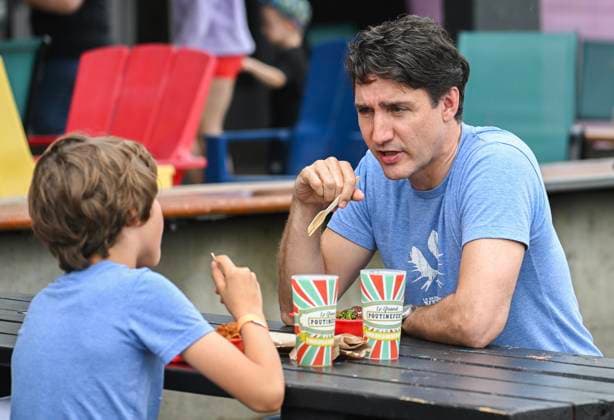 June 23, 2024, Chateauguay, Pq, Canada: Prime Minister Justin Trudeau and son Hadrien eat poutines as they visit a poutine festival in Chateauguay, Que., Sunday, June 23, 2024. Chateauguay Canada  - ZUMAc35_ 20240623_zaf_c35_003 Copyright: xGrahamxHughesx