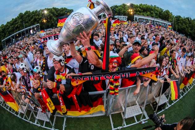Euro 2024 public viewing in Berlin Germany vs. Austria, fan zone in front of the Brandenburg Gate The fans cheer on the team and hold up a trophy Berlin Berlin Germany