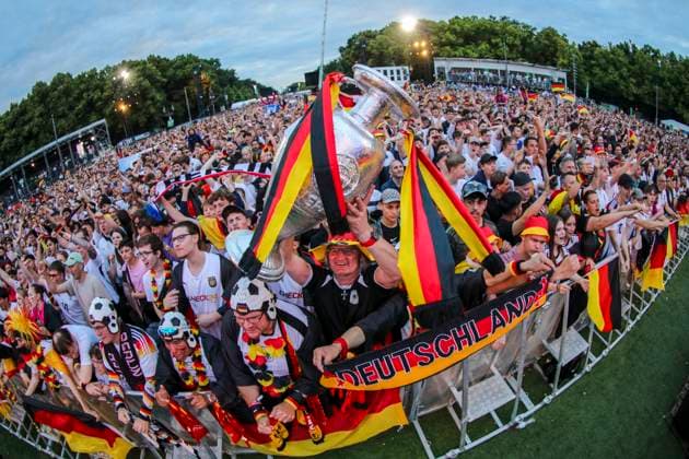 Euro 2024 public viewing in Berlin Germany vs. Austria, fan zone in front of the Brandenburg Gate The fans cheer on the team and hold up a trophy Berlin Berlin Germany