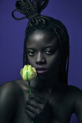 Creative Highlights Symbolbilder Young black woman holding yellow flower on blue Wroc?aw, Lower Silesian Voivodeship, Poland CR_PJWUOI240620C-1466944-01 ,model released, Symbolfoto