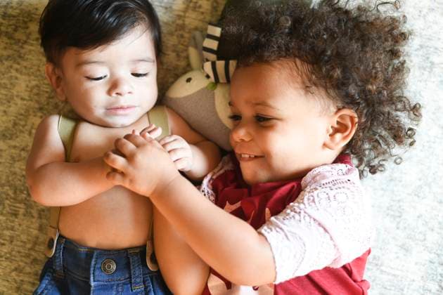 Creative Highlights Symbolbilder Two children lying together, smiling, and holding hands. United States, Florida, Inverness R_YWQX240623D-1468441-01 ,model released, Symbolfoto