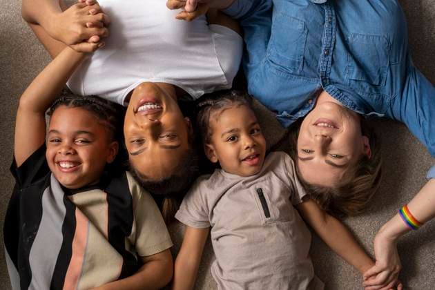 IMAGO Creative, Diversity, Familie: Gleichgeschlechtliche Eltern: Zwei Mütter Portrait of mothers and sons cuddling on floor model released Copyright: xCulturaxCreativexWhollyxOwnedx