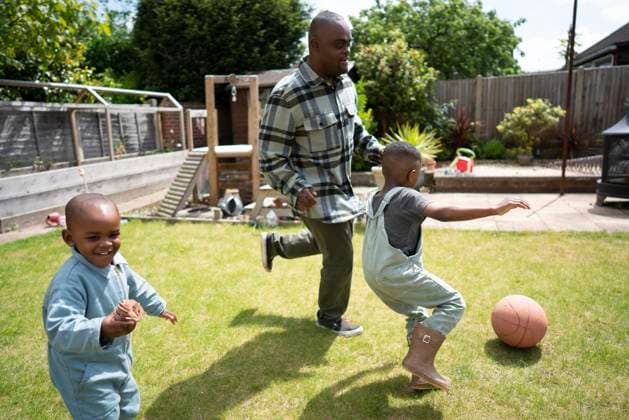 Father with Down syndrome playing soccer with sons (2-3, 4-5) model released Copyright: xCulturaxCreativexRFx