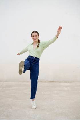 Creative Highlights Symbolbilder Cheerful woman balancing on one leg in front on wall model released, Symbolfoto, JSMF03014