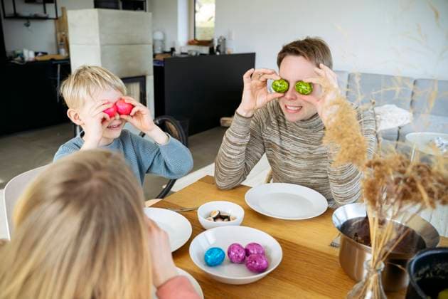 Man covering eyes with colored eggs sitting by playful son and daughter at dining table model released, Symbolfoto property released, NJAF01127