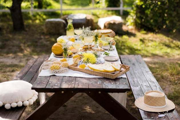 IMAGO Creative, Lifestyle, Feste im Garten #2 Wooden picnic table decorated with various food in garden, ONAF00859